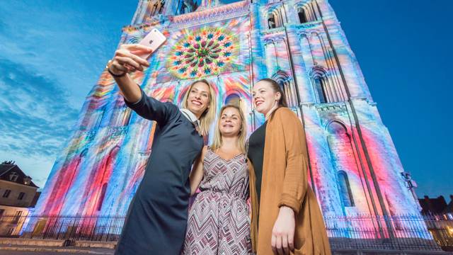 Jeunes femmes prenant un selfie devant la façade de la cathédrale lors de Chartres en lumières